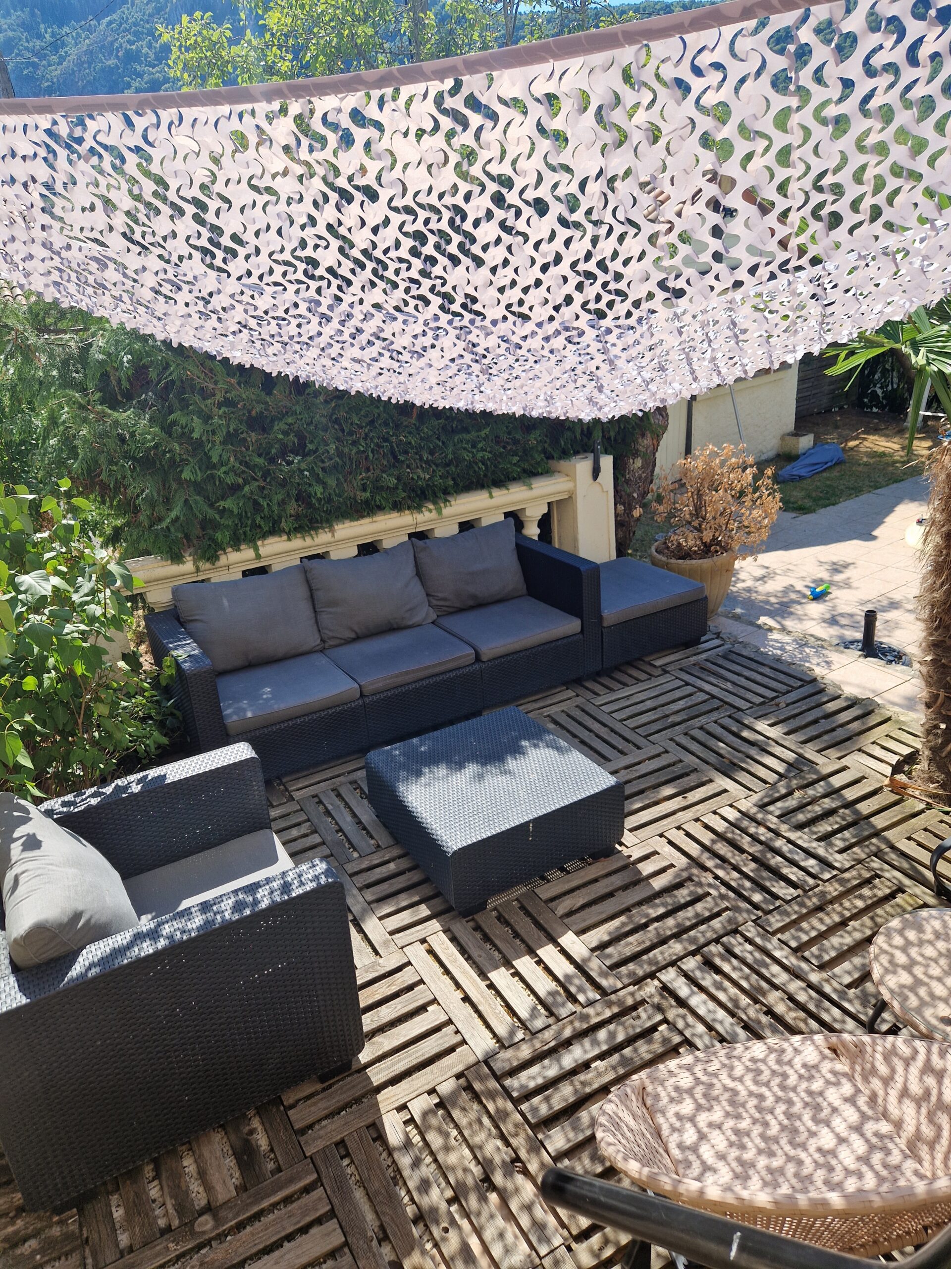Poolside terrace with outdoor furniture with camo sun shade